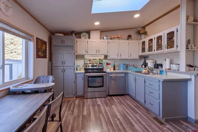 a kitchen with stainless steel appliances granite countertop a refrigerator a stove and white cabinets