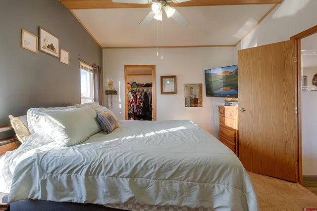 a bedroom with a bed and a large mirror