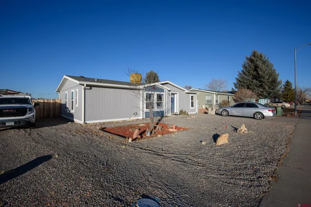 a front view of a house with cars parked
