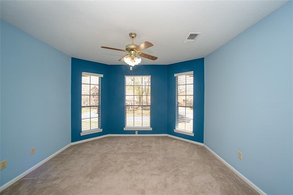 28816 South Diamondhead Conroe, TX 77356 - Photo 18 of 23 an empty room with windows and ceiling fan