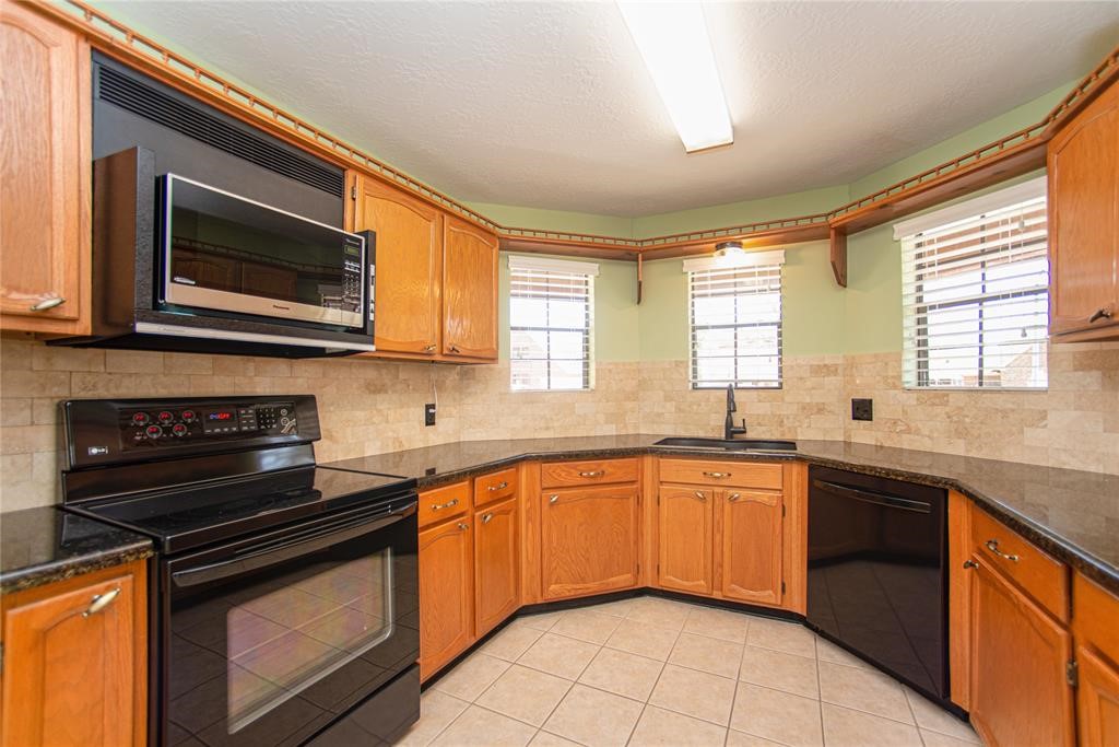 28816 South Diamondhead Conroe, TX 77356 - Photo 7 of 23 a kitchen with stainless steel appliances granite countertop stove top oven microwave and cabinets
