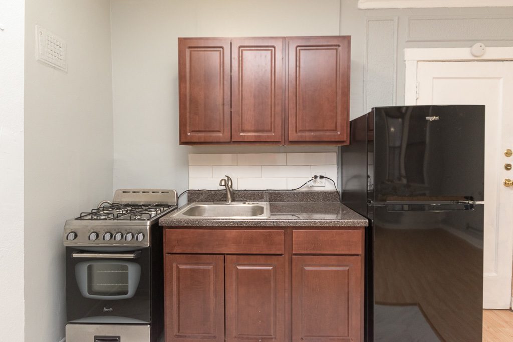 4735 North Beacon Street, Unit 314 Chicago, IL 60640 - Photo 2 of 15 a kitchen with granite countertop a sink stove and cabinets