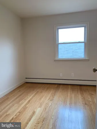 a view of a room with wooden floor and a window