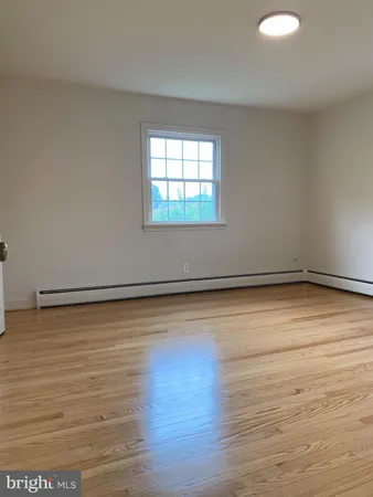 a view of a room with wooden floor and white walls