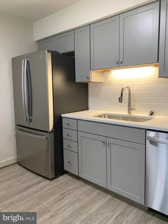 a kitchen with a refrigerator sink and cabinets