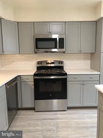 a kitchen with granite countertop a stove and a microwave