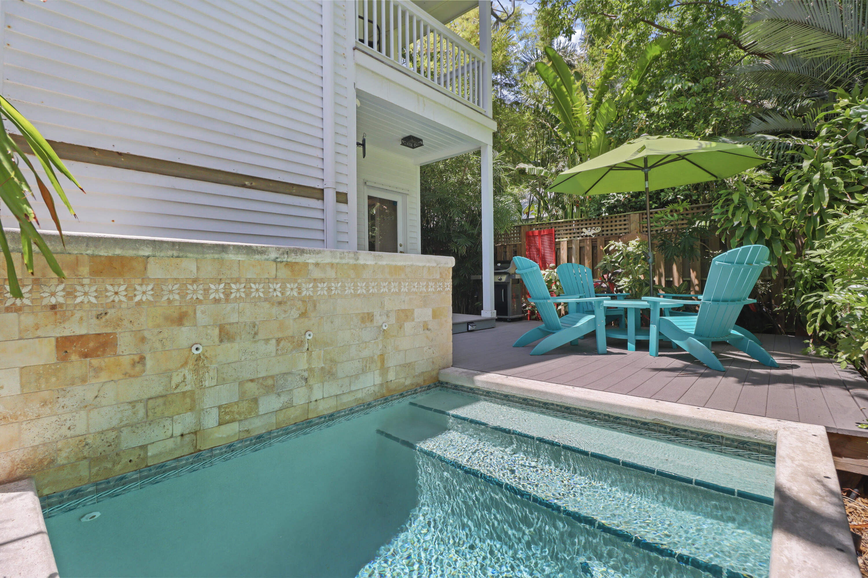 1033 Catherine Street Key West, FL 33040 - Photo 5 of 39 a backyard of a house with table and chairs under an umbrella