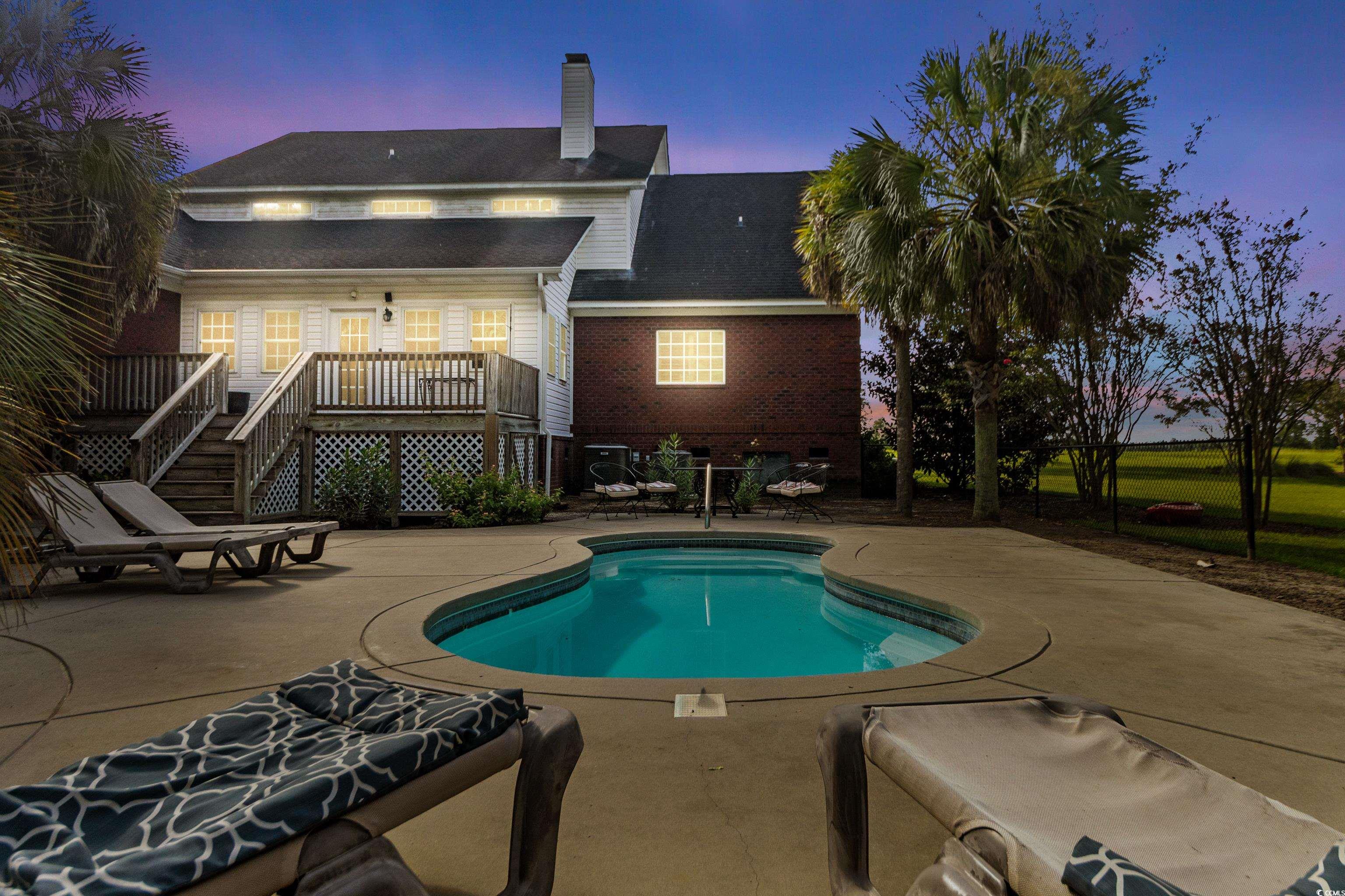 5414 Hampton Road Conway, SC 29527 - Photo 7 of 39 Pool at dusk with stairs, an outdoor pool, a patio, and a wooden deck