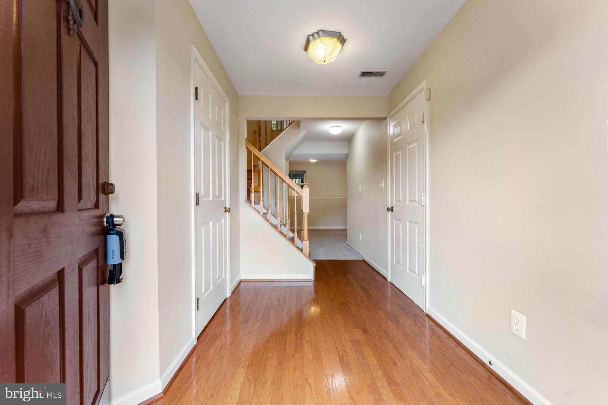 12734 Silvia Loop Woodbridge, VA 22192 - Photo 2 of 22 a view of a hallway with wooden floor and staircase