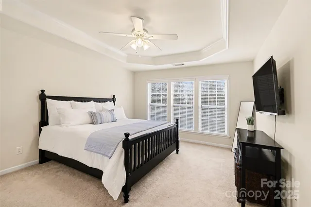 a spacious bedroom with a bed and a flat screen tv