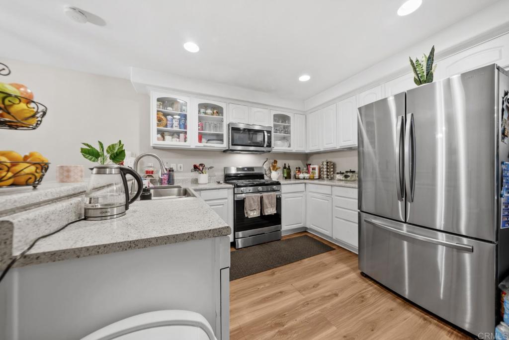 154 East 11th Street Perris, CA 92570 - Photo 11 of 37 a kitchen with granite countertop stainless steel appliances a refrigerator and a stove top oven