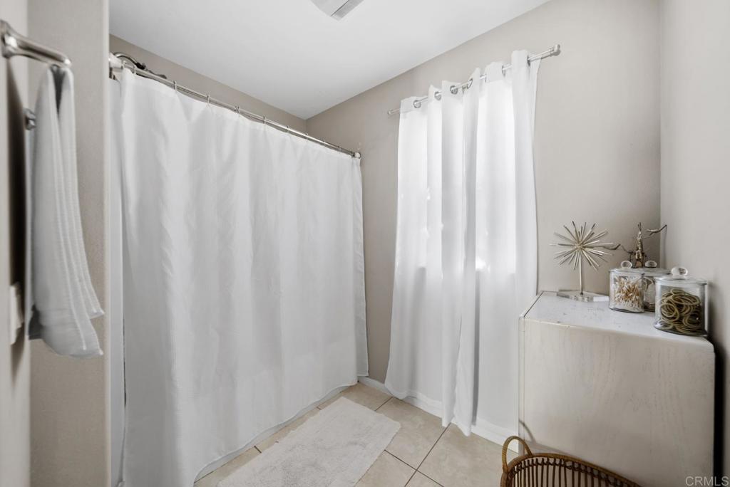 154 East 11th Street Perris, CA 92570 - Photo 17 of 37 a bathroom with a sink a mirror and a shower curtain