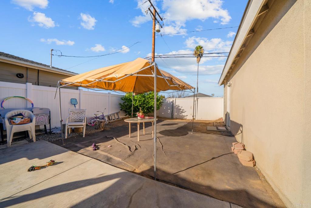 154 East 11th Street Perris, CA 92570 - Photo 24 of 37 a patio with a table and chairs under an umbrella