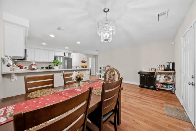 a kitchen with stainless steel appliances kitchen island granite countertop a table and chairs in it