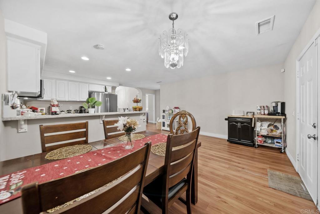 154 East 11th Street Perris, CA 92570 - Photo 8 of 37 a kitchen with stainless steel appliances kitchen island granite countertop a table and chairs in it