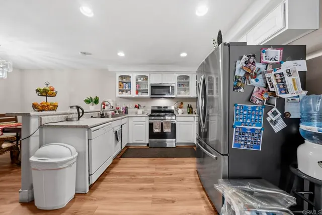 a kitchen with stainless steel appliances a refrigerator sink and wooden cabinets