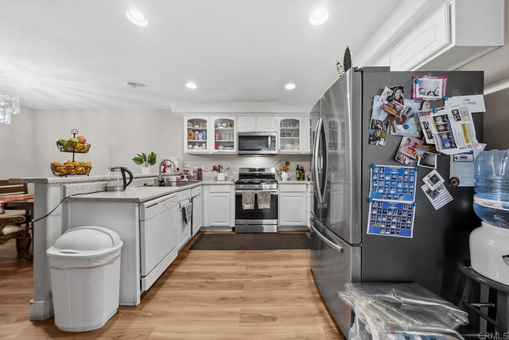 154 East 11th Street Perris, CA 92570 - Photo 10 of 37 a kitchen with stainless steel appliances a refrigerator sink and wooden cabinets