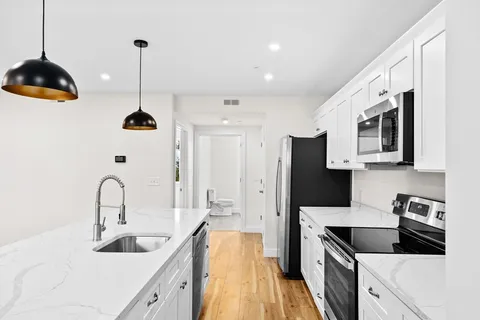 a kitchen with stainless steel appliances granite countertop a sink a stove and a refrigerator