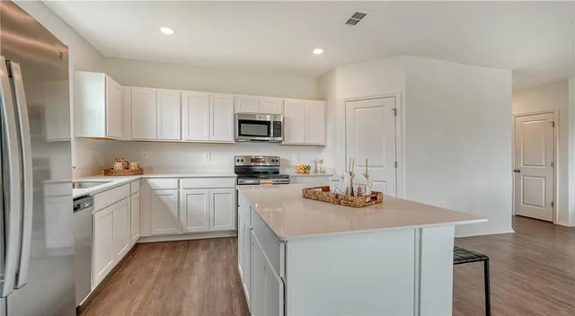 a kitchen with granite countertop a sink stove and cabinets