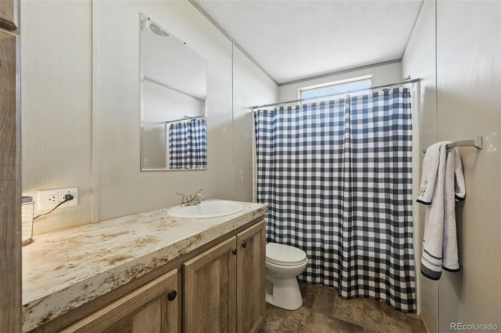 30890 Ken View Yoder, CO 80864 - Photo 25 of 36 a bathroom with a granite countertop sink toilet and shower