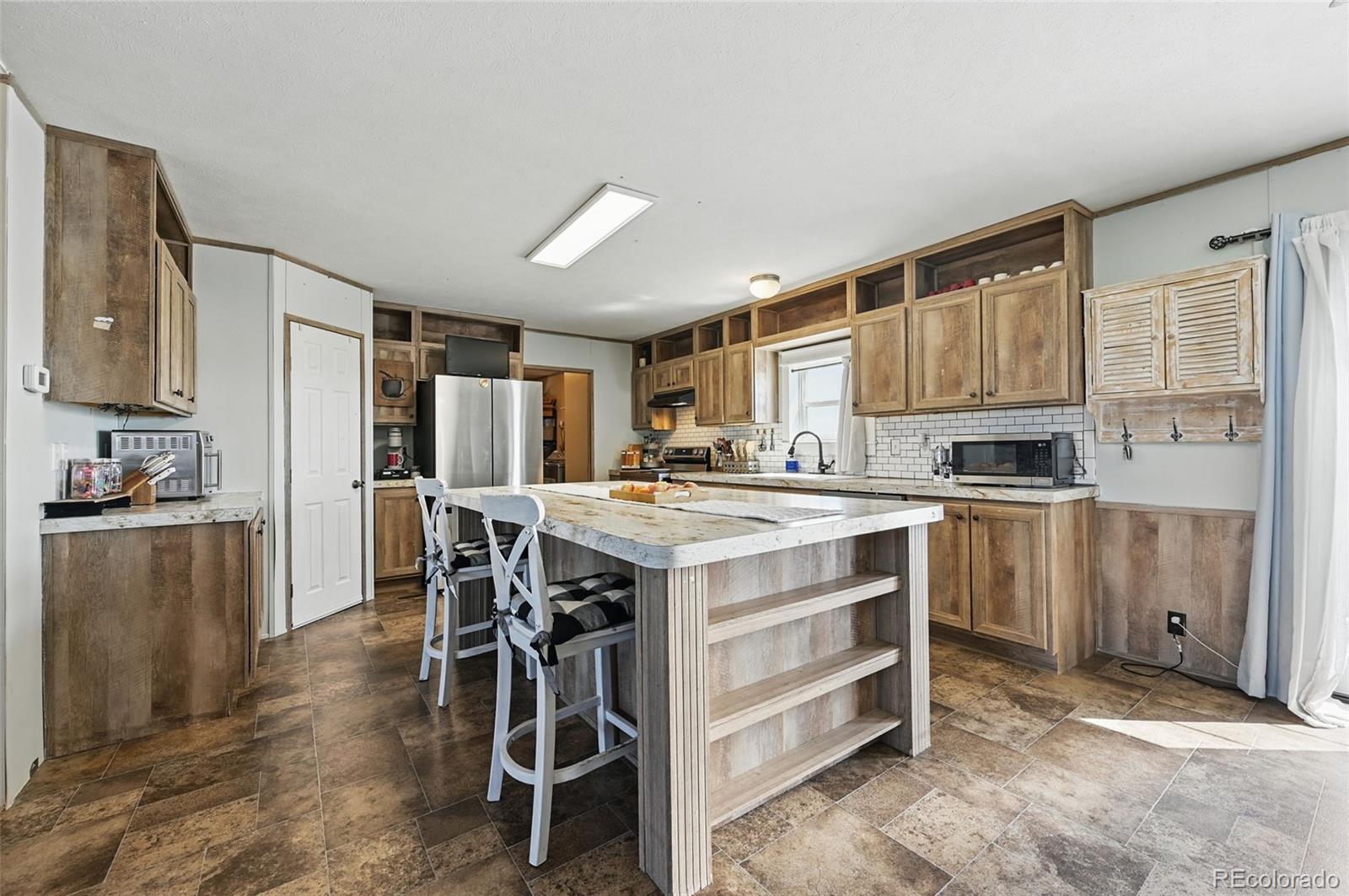 30890 Ken View Yoder, CO 80864 - Photo 7 of 36 a kitchen with a table chairs refrigerator and cabinets