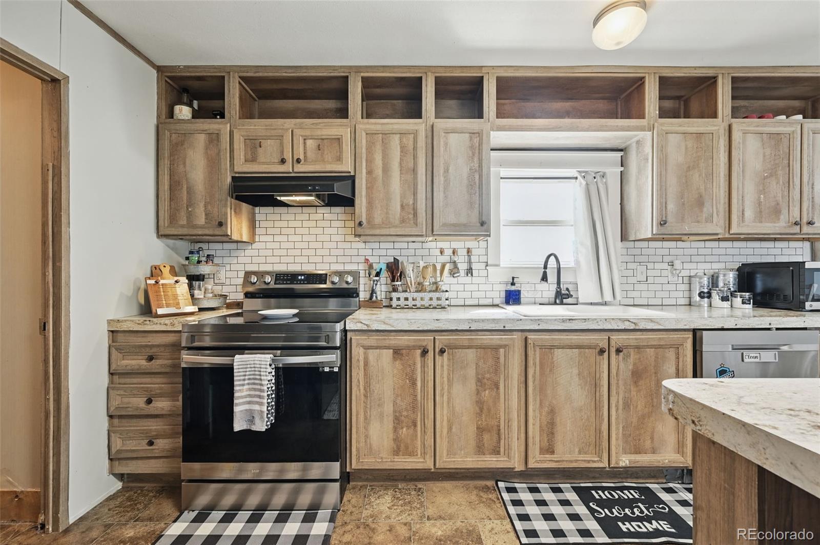 30890 Ken View Yoder, CO 80864 - Photo 10 of 36 a kitchen with stainless steel appliances granite countertop a stove a sink and a microwave