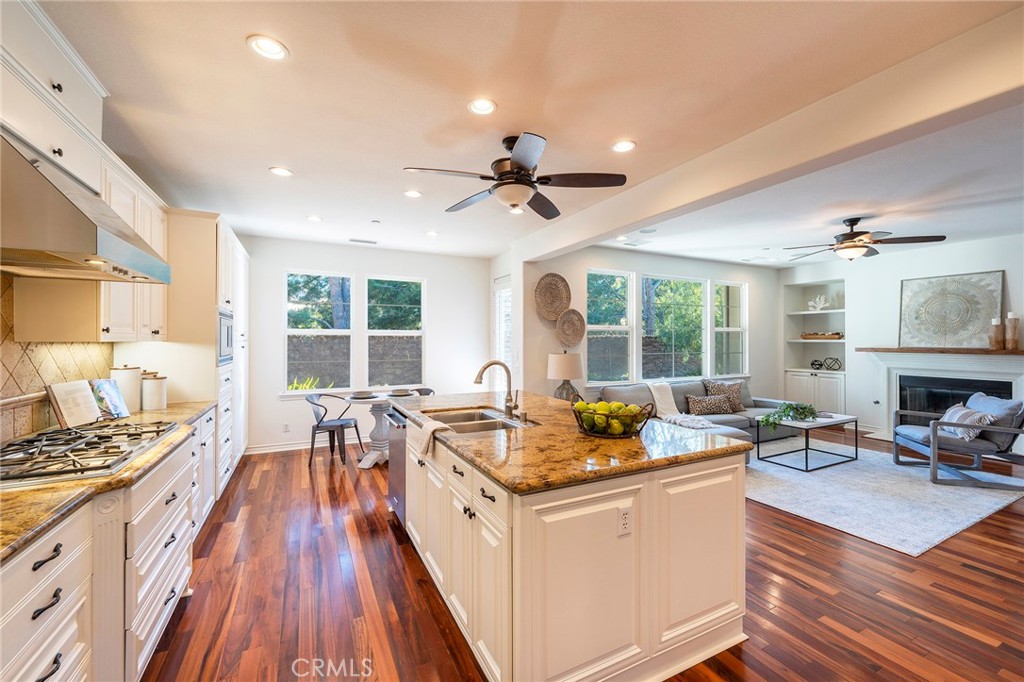 6 Shepherd Court Ladera Ranch, CA 92694 - Photo 12 of 68 a kitchen with a stove a sink a dining table and chairs with wooden floor
