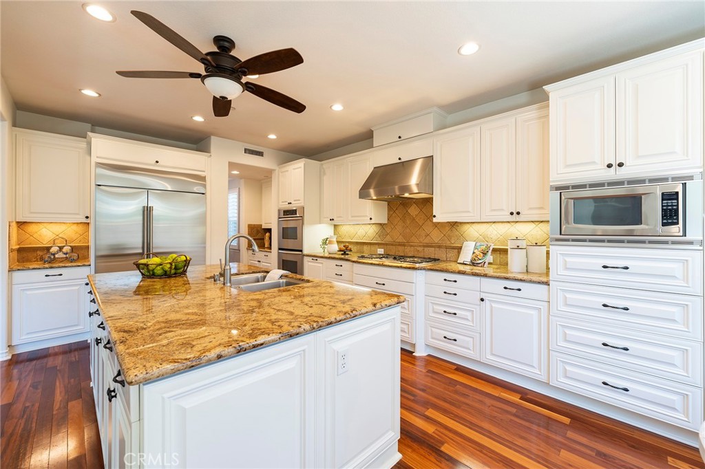6 Shepherd Court Ladera Ranch, CA 92694 - Photo 14 of 68 a kitchen with granite countertop kitchen island stainless steel appliances a stove sink and microwave
