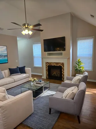 a living room with furniture a flat screen tv and a fireplace