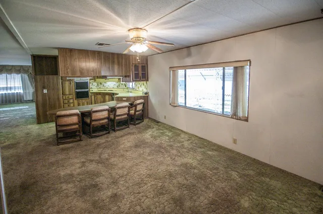 a view of a livingroom with furniture and a refrigerator