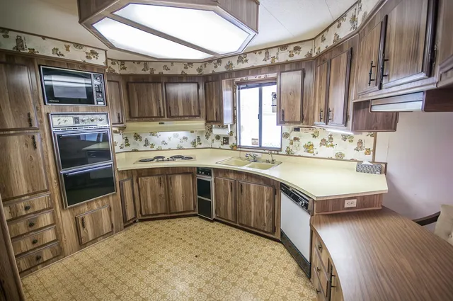 a kitchen with kitchen island a sink stove and refrigerator