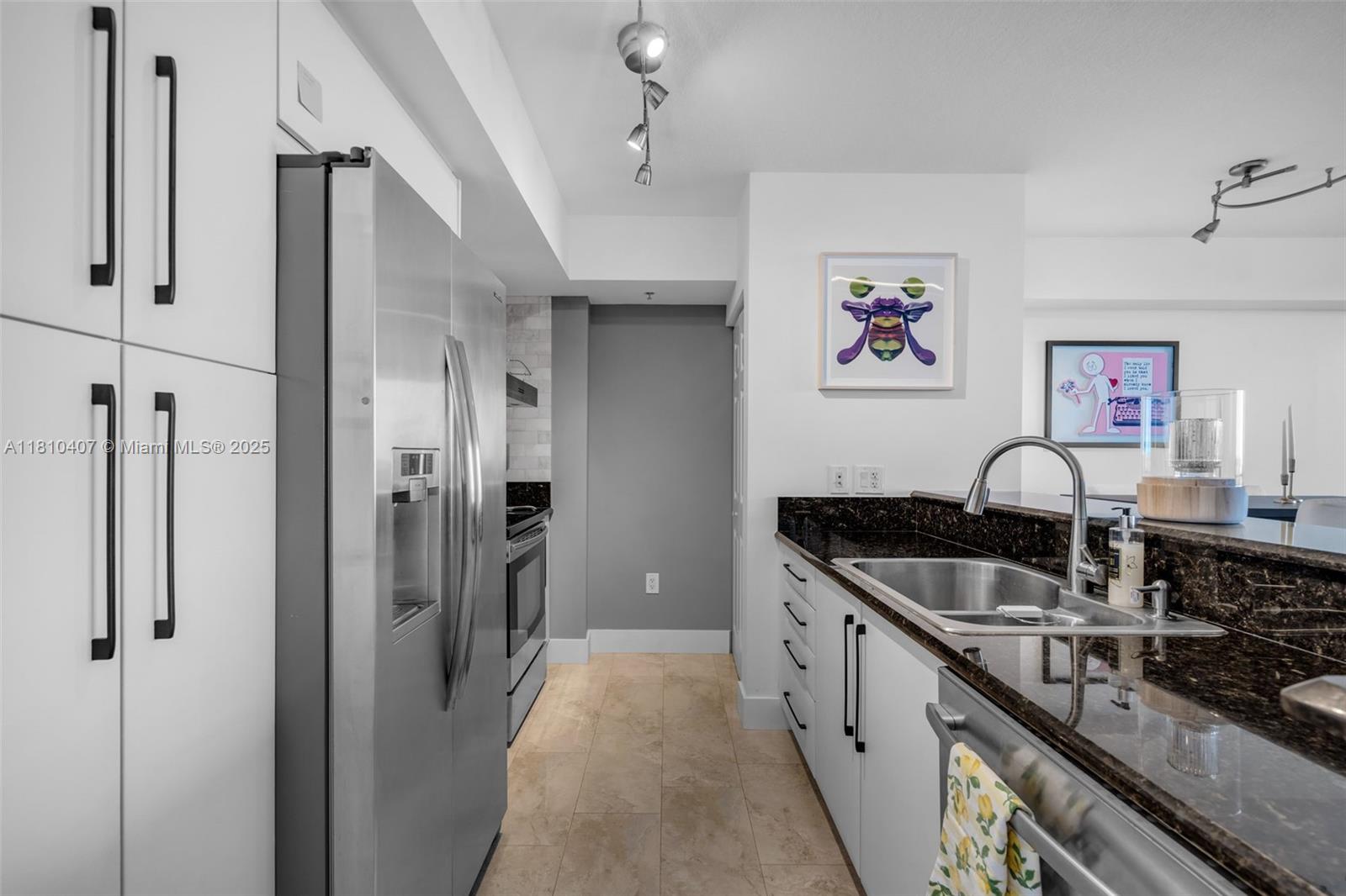 3232 Southwest 22nd Terrace, Unit 1106 Miami, FL 33145 - Photo 6 of 22 a kitchen with stainless steel appliances granite countertop a refrigerator and a sink