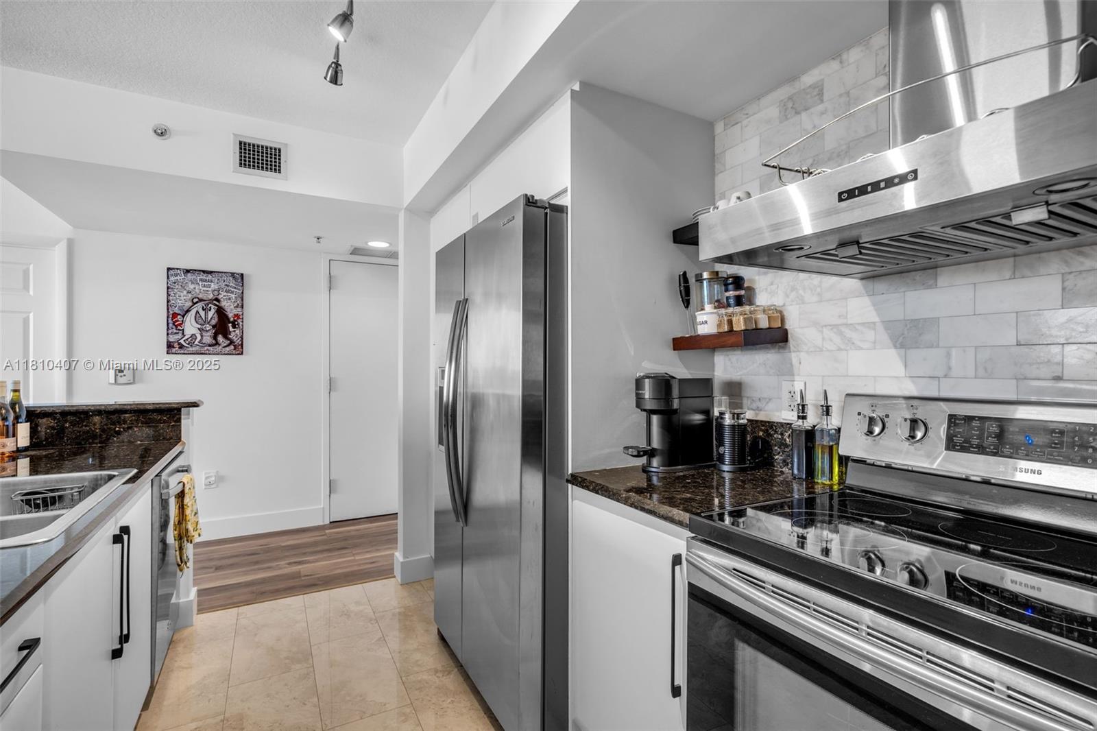 3232 Southwest 22nd Terrace, Unit 1106 Miami, FL 33145 - Photo 7 of 22 a kitchen with stainless steel appliances granite countertop a stove and a refrigerator