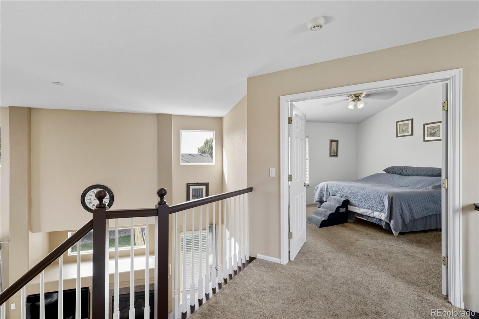 10245 Dusk Street Firestone, CO 80504 - Photo 15 of 24 a spacious bedroom with a bed and a chandelier