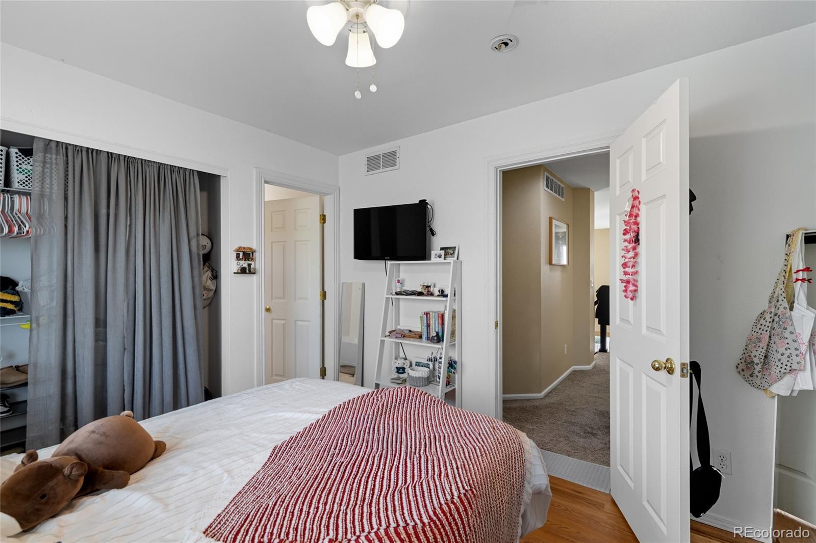 10245 Dusk Street Firestone, CO 80504 - Photo 24 of 24 a bedroom with a bed and a flat tv screen on dresser