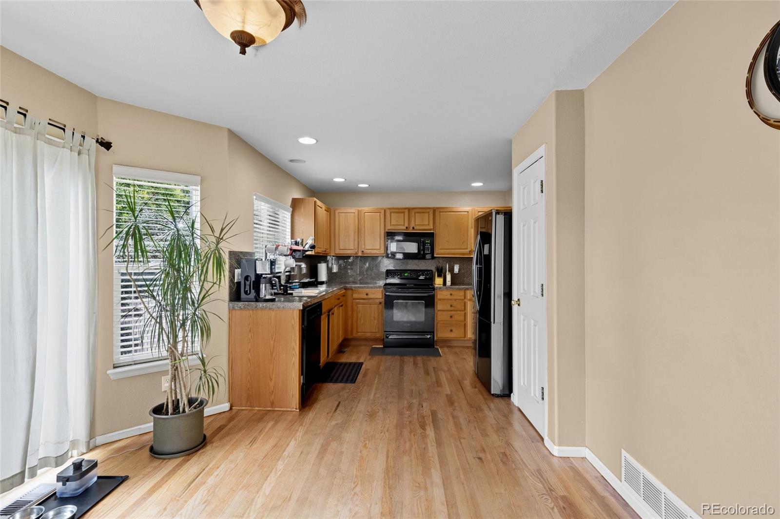 10245 Dusk Street Firestone, CO 80504 - Photo 10 of 24 a kitchen with white cabinets and stainless steel appliances