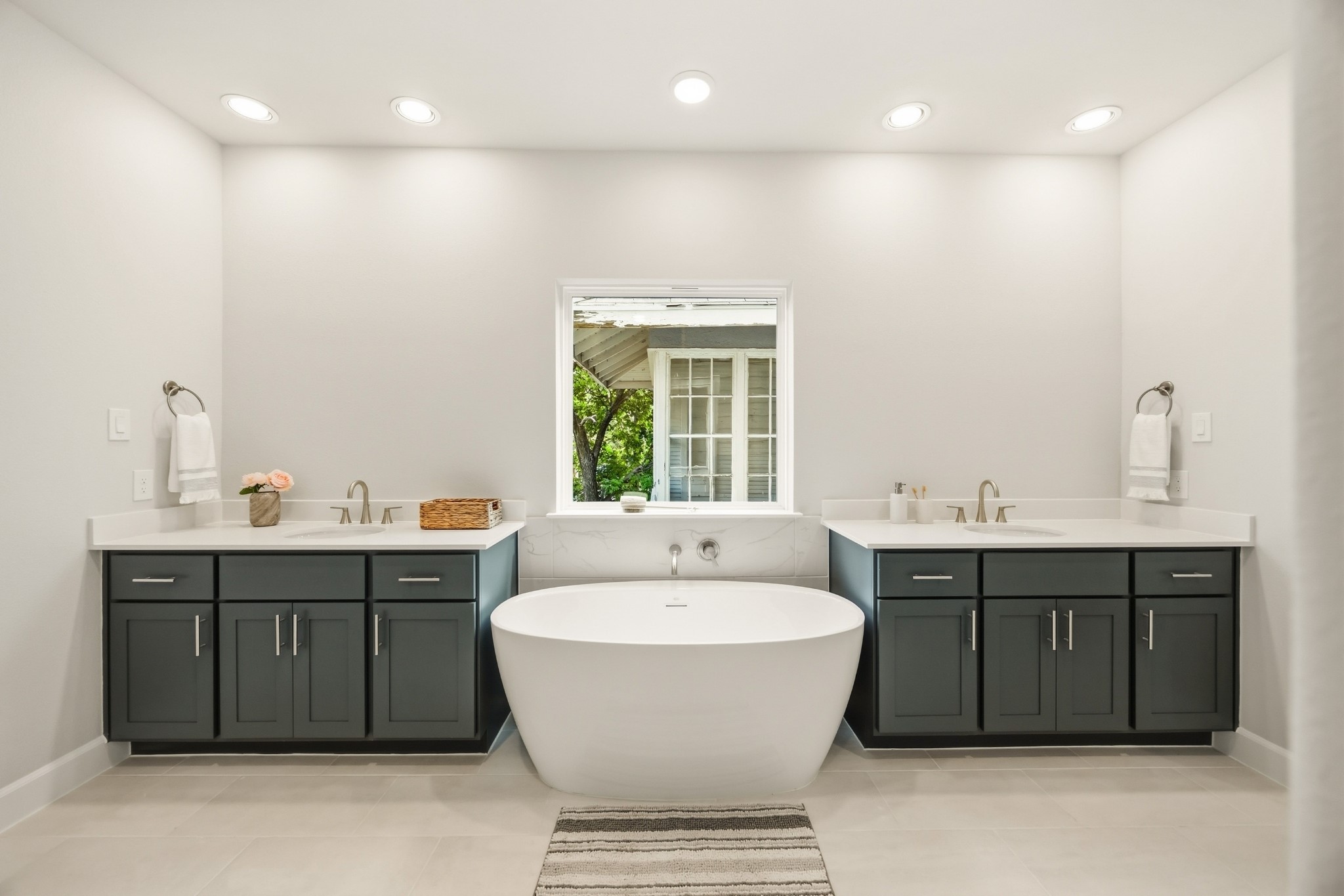4317 Roseland Street, Unit B Houston, TX 77006 - Photo 19 of 29 Step into an oasis featuring a vessel tub set between dual vanities, framed by custom wood cabinets and quartz countertops, for an unwavering indulgence.