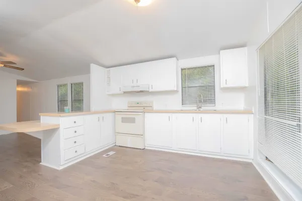 a kitchen with white cabinets and white appliances