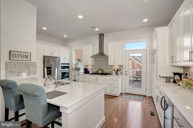 a kitchen with stainless steel appliances kitchen island granite countertop a refrigerator and a stove top oven
