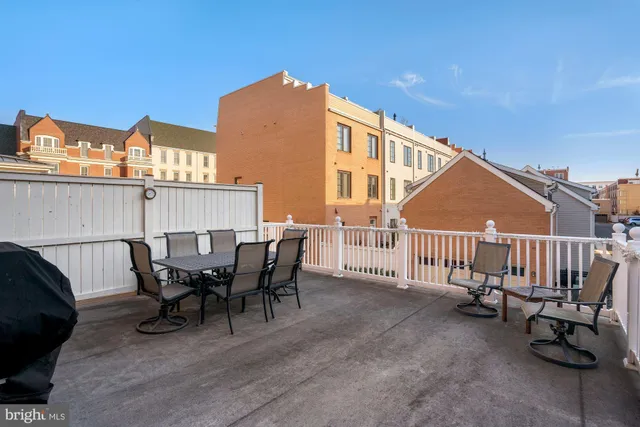 a view of a house with a deck and furniture