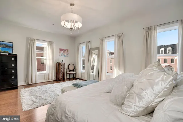 a bedroom with a bed and a chandelier