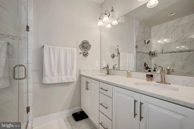 a bathroom with a double vanity sink mirror and shower