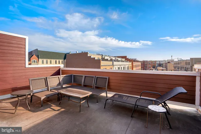 a roof deck with a couch and chairs