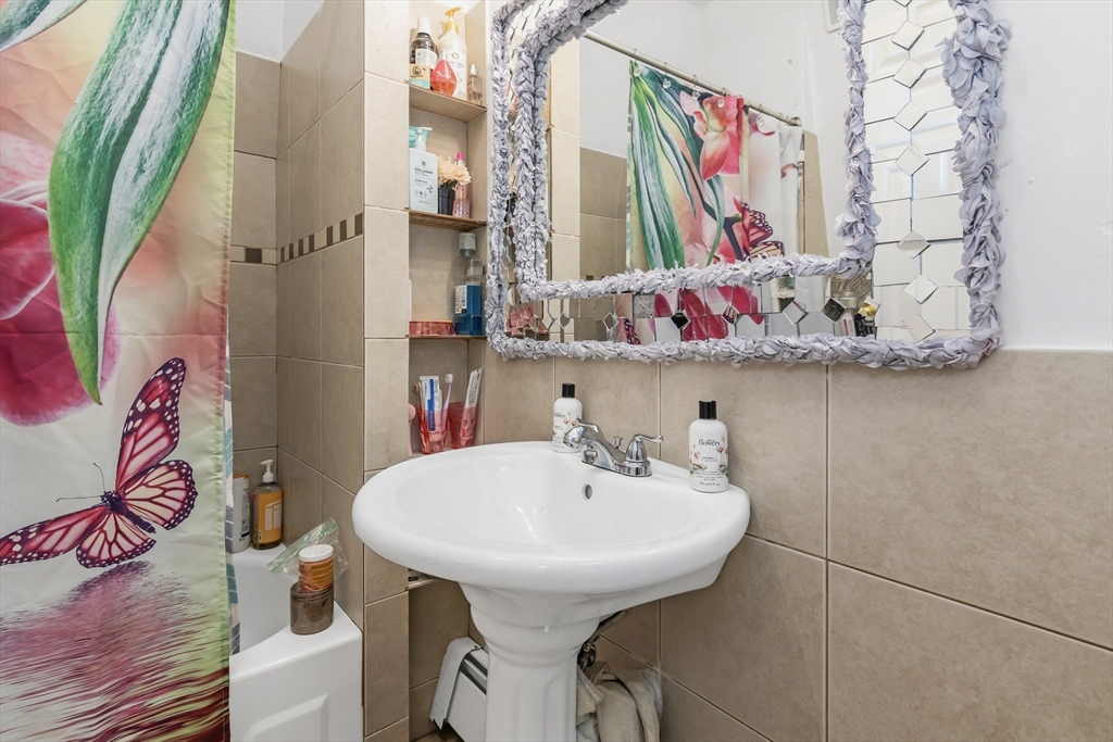 191 Farnham Street Lawrence, MA 01843 - Photo 23 of 31 a bathroom with a sink and mirror with wooden floor
