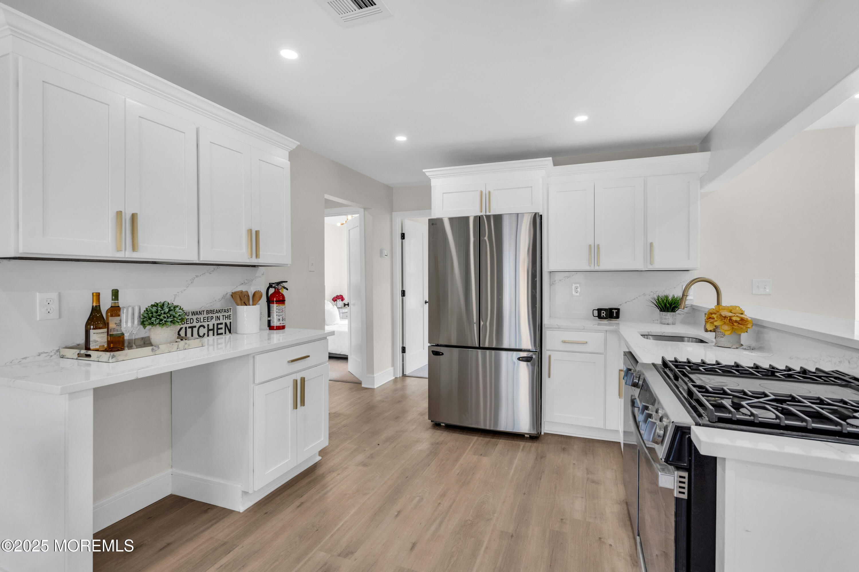 882 Radio Road Little Egg Harbor, NJ 08087 - Photo 11 of 24 a kitchen with stainless steel appliances white cabinets and wooden floor