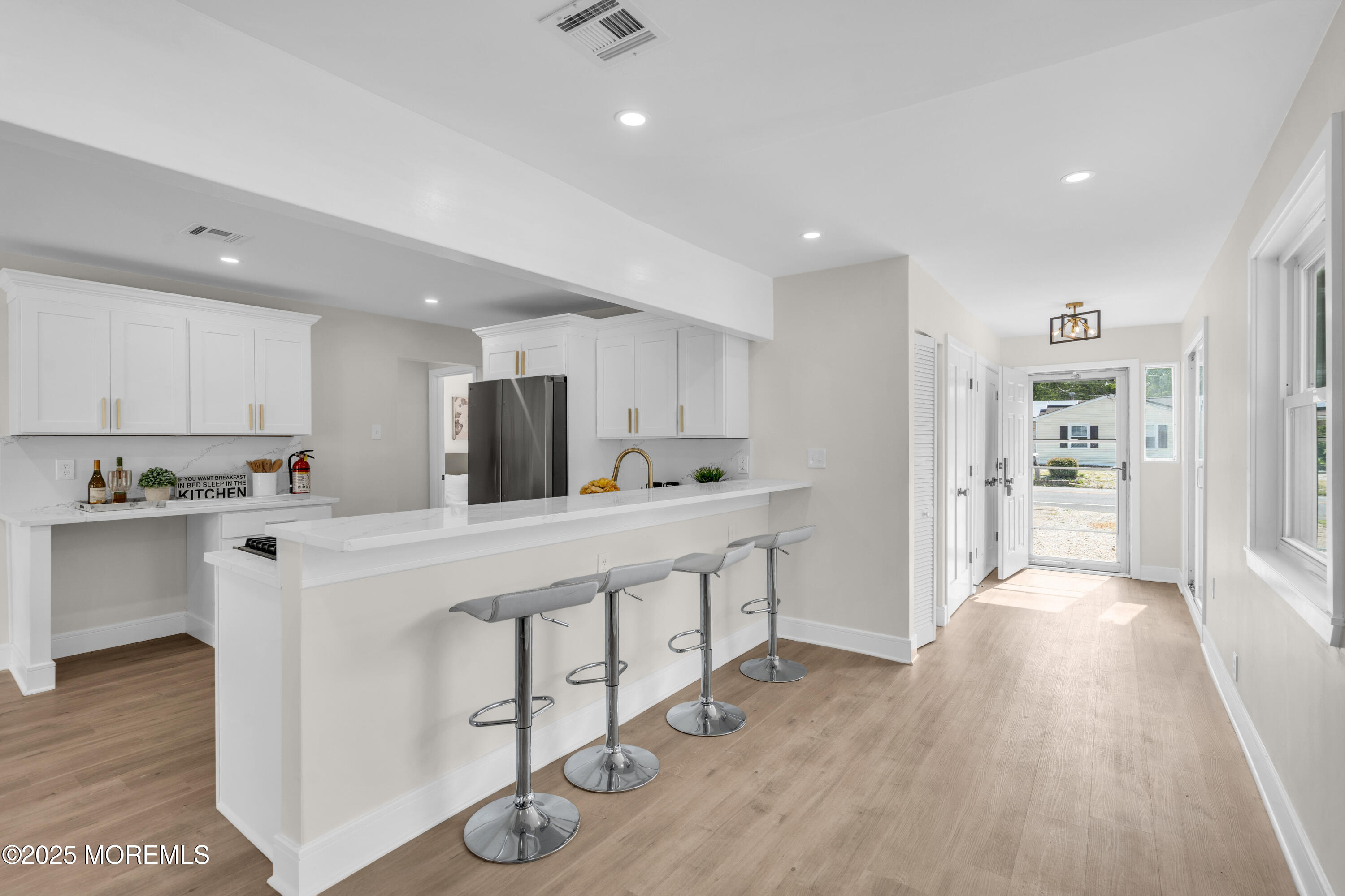 882 Radio Road Little Egg Harbor, NJ 08087 - Photo 5 of 24 a large white kitchen with wooden floors and stainless steel appliances