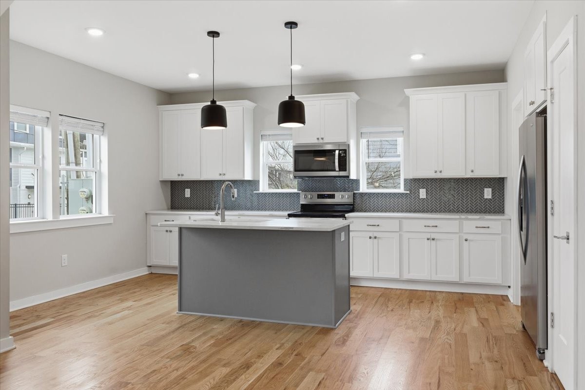 109 A Duke Street Nashville, TN 37207 - Photo 6 of 21 a kitchen with stainless steel appliances granite countertop a stove a sink and a microwave