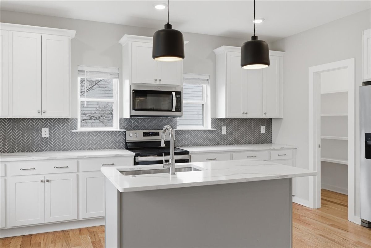 109 A Duke Street Nashville, TN 37207 - Photo 8 of 21 a kitchen with stainless steel appliances a sink a stove a microwave a refrigerator a center island and cabinets