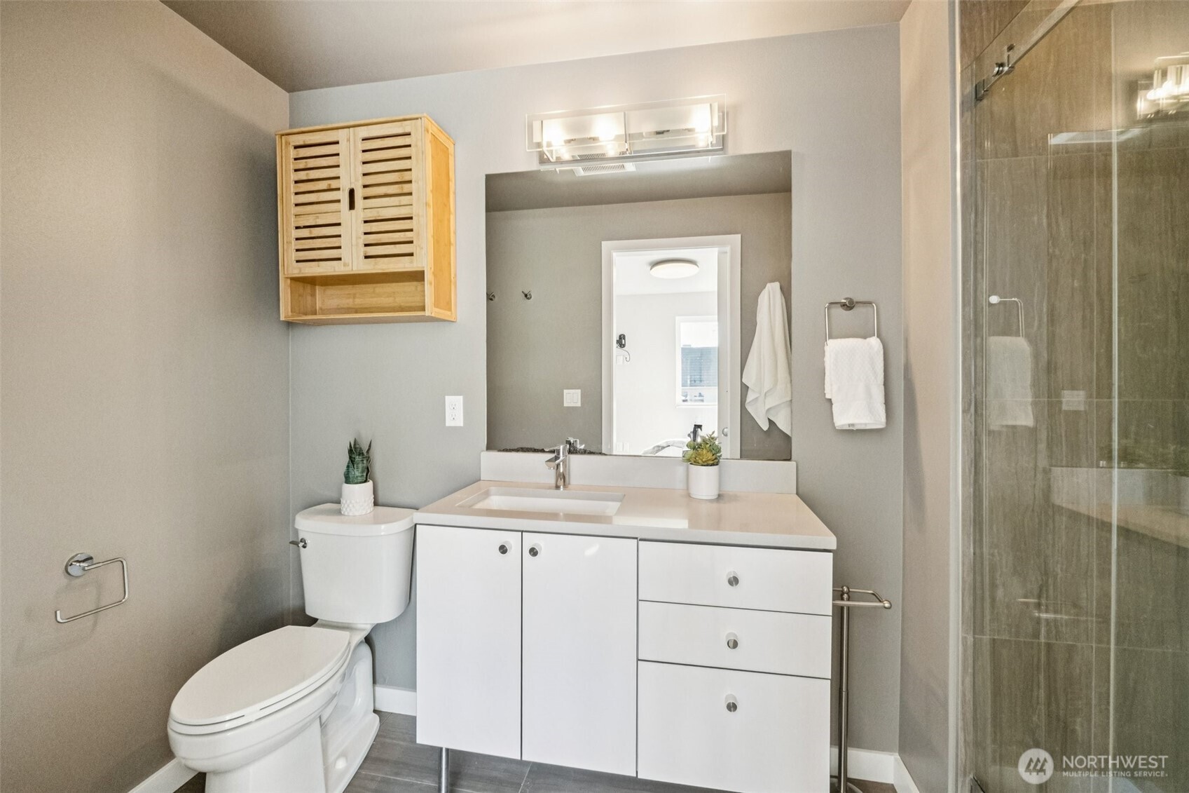 2653 Northwest 64th Street, Unit A Seattle, WA 98107 - Photo 13 of 22 a bathroom with a toilet a sink a mirror a shower a vanity and window