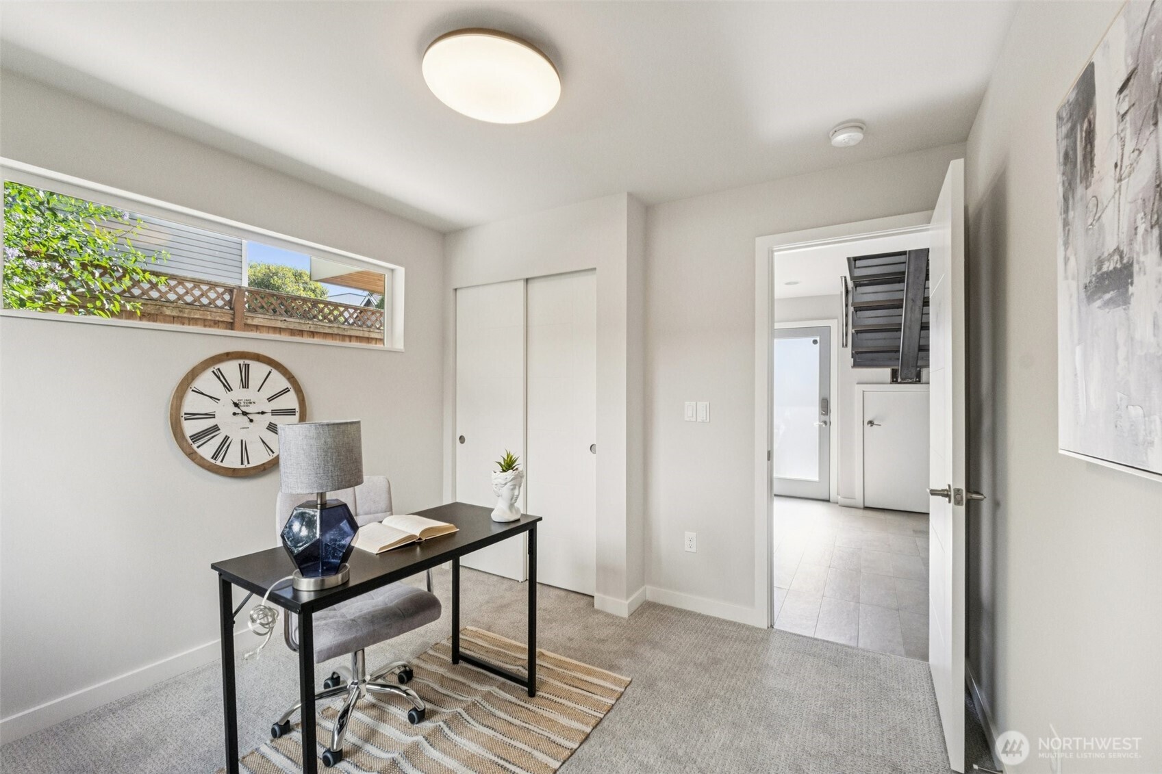 2653 Northwest 64th Street, Unit A Seattle, WA 98107 - Photo 17 of 22 a view of a hallway that has a table and a chair in it